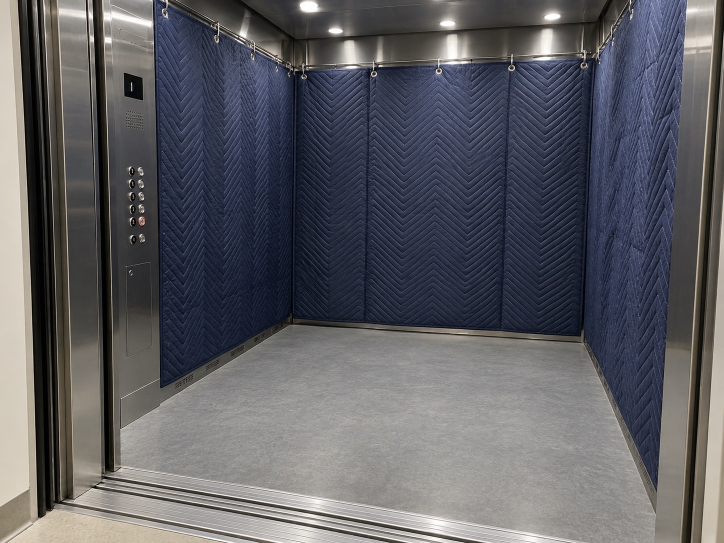 Navy quilted protective pads lining a service elevator